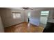 Bedroom with wood floors, window with blinds, access to bathroom, and closet at 5998 8Th S St, St Petersburg, FL 33705