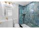 Modern bathroom featuring blue-toned tile shower, hexagon tile floor, white vanity and gold fixtures at 6012 Larmon St, Tampa, FL 33634