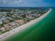 Breathtaking aerial view of beachfront property, highlighting its proximity to the sandy beach and tranquil ocean waters at 614 Gulf Blvd # 4, Indian Rocks Beach, FL 33785