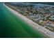 Expansive aerial view showcasing beachfront real estate along the coastline, with ocean views and city skyline at 614 Gulf Blvd # 4, Indian Rocks Beach, FL 33785