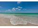 Close up of a beach with waves gently rolling onto the shore under a blue sky at 614 Gulf Blvd # 4, Indian Rocks Beach, FL 33785