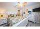 Tranquil bedroom with tropical-themed bedding, white furniture, and an open doorway to an adjacent bathroom at 614 Gulf Blvd # 4, Indian Rocks Beach, FL 33785