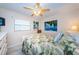 Cozy bedroom with a tropical-themed bedspread, white dresser, and ceiling fan for a relaxing retreat at 614 Gulf Blvd # 4, Indian Rocks Beach, FL 33785