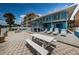 Exterior shot featuring white lounge chairs, picnic table, and paver patio at 614 Gulf Blvd # 4, Indian Rocks Beach, FL 33785