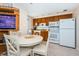 Cozy eat-in kitchen features wood cabinets, white appliances, and a charming breakfast nook at 614 Gulf Blvd # 4, Indian Rocks Beach, FL 33785