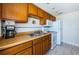 Spacious kitchen with plenty of wood cabinetry, an electric range, and tile backsplash at 614 Gulf Blvd # 4, Indian Rocks Beach, FL 33785