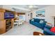 Cozy living room featuring a comfortable blue sofa, dining area, and an entertainment center with a TV at 614 Gulf Blvd # 4, Indian Rocks Beach, FL 33785