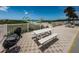 Brick patio with white picnic table, grill and lush dunes leading to a white sandy beach at 614 Gulf Blvd # 4, Indian Rocks Beach, FL 33785