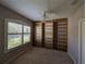 Bedroom view showing a built-in bookcase, ceiling fan, and large window for plenty of light at 8530 Alexandra Arbor Ln, Temple Terrace, FL 33637