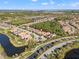 Aerial view of a residential community featuring lush landscaping, multiple homes, and water features at 9708 Highland Park Pl, Palmetto, FL 34221