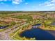 Scenic aerial view of a community with a lake, bridge, and well-maintained landscaping and lush green spaces at 9708 Highland Park Pl, Palmetto, FL 34221