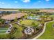 Expansive aerial view of community amenities including a pool, clubhouse, fire pit, and meticulously landscaped grounds at 9708 Highland Park Pl, Palmetto, FL 34221