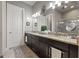 Bathroom featuring double vanity with granite countertop, modern fixtures, and dark wood cabinets at 9708 Highland Park Pl, Palmetto, FL 34221