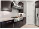 Gourmet kitchen with stainless steel gas range and modern vent hood, and dark wood cabinetry at 9708 Highland Park Pl, Palmetto, FL 34221