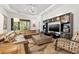 Bright living room with a comfortable sectional sofa, modern ceiling fan, and custom entertainment center at 9708 Highland Park Pl, Palmetto, FL 34221