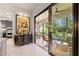 View of the indoor/outdoor living space, leading to a screened lanai with lush landscaping at 9708 Highland Park Pl, Palmetto, FL 34221