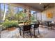 Cozy screened-in patio with comfortable seating, decorative lighting, and serene views of the well-maintained yard at 9708 Highland Park Pl, Palmetto, FL 34221
