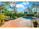 Backyard featuring a pool with brick pavers, a wood deck with a bench, and lush landscaping at 11712 Palmer Dr, Tampa, FL 33624