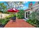 Backyard featuring a small deck with outdoor seating, a red umbrella, and lush landscaping at 11712 Palmer Dr, Tampa, FL 33624