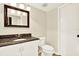 Bathroom features a white vanity with granite countertops and dark wood-framed mirror at 11712 Palmer Dr, Tampa, FL 33624