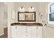 Bathroom vanity featuring dual sinks, granite countertop, modern lighting, and decorative mirror at 11712 Palmer Dr, Tampa, FL 33624