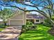 Exterior of home featuring mature trees, front yard landscaping, and a brick driveway at 11712 Palmer Dr, Tampa, FL 33624