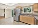Well-lit kitchen featuring stainless steel appliances, granite countertops, and a window overlooking the backyard at 11712 Palmer Dr, Tampa, FL 33624
