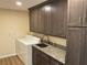 Laundry room features a large sink, washer and dryer, and modern dark wood cabinetry at 11712 Palmer Dr, Tampa, FL 33624