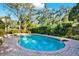 Backyard pool surrounded by brick pavers and lush landscaping at 11712 Palmer Dr, Tampa, FL 33624