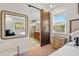 Tastefully designed bathroom with a barn door, a well-lit vanity and a walk in shower at 11714 Wrought Pine Loop, Riverview, FL 33569