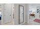 Bright hallway featuring wood floors, decorative mirror, and views of the dining and living areas at 11714 Wrought Pine Loop, Riverview, FL 33569