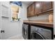 Well-organized laundry room with front-loading washer and dryer and upper cabinets for storage at 11714 Wrought Pine Loop, Riverview, FL 33569