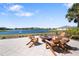 Waterfront patio seating around a fire pit offers a relaxing outdoor space with scenic views and comfortable wooden chairs at 11714 Wrought Pine Loop, Riverview, FL 33569