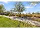 A serene outdoor setting with park benches surrounded by lush greenery, trees, and a sidewalk under a clear blue sky at 11714 Wrought Pine Loop, Riverview, FL 33569