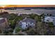 Aerial view of estate with water views at sunset, nestled among mature trees at 12808 Harborwood Dr, Largo, FL 33774