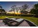 Backyard patio and seating area at dusk, offering serene views of the surrounding landscape at 12808 Harborwood Dr, Largo, FL 33774