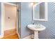 Bathroom with stylish blue wallpaper, pedestal sink, and glass-enclosed shower at 12808 Harborwood Dr, Largo, FL 33774