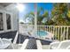 Relaxing deck with white railings and comfortable chairs overlooking a beautiful pool and lush tropical foliage at 12808 Harborwood Dr, Largo, FL 33774