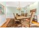 A dining room with a large wood table, upholstered chairs, a decorative rug, and ample natural light at 12808 Harborwood Dr, Largo, FL 33774