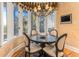 A sunny dining nook with a dark wood table, upholstered chairs, large windows, and decorative chandelier at 12808 Harborwood Dr, Largo, FL 33774