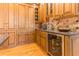 An elegant kitchen featuring custom wood cabinets, stone backsplash, and a built-in wine refrigerator at 12808 Harborwood Dr, Largo, FL 33774