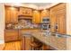 Beautiful kitchen with wood cabinets, granite countertops, stainless steel appliances, and a central island with seating at 12808 Harborwood Dr, Largo, FL 33774