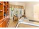 Well-lit home office with a unique metal desk, built-in bookcase, and patio access at 12808 Harborwood Dr, Largo, FL 33774