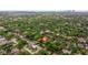 Aerial view featuring dense trees enveloping cozy homes set against a distant city skyline on a sunny day at 1301 45Th N Ave, St Petersburg, FL 33703