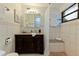Neutral bathroom with a dark vanity, stone countertop, and tiled shower at 1301 45Th N Ave, St Petersburg, FL 33703