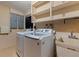 Bright laundry room with modern washer and dryer, utility sink, and ample shelving at 1301 45Th N Ave, St Petersburg, FL 33703