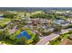 An aerial shot showcasing a beautiful community clubhouse with a pool, ponds, lush landscaping, and parking at 1319 Leland Dr # 101, Sun City Center, FL 33573