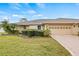 Charming single-story home with a well-manicured lawn, mature trees, and an attached two-car garage at 1319 Leland Dr # 101, Sun City Center, FL 33573