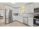 Bright kitchen features stainless steel appliances, gray backsplash, granite counters, and white cabinets at 1319 Leland Dr # 101, Sun City Center, FL 33573