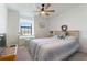 Well-lit bedroom featuring a bed, ceiling fan, and a work table by the window, creating a cozy atmosphere at 15041 Sea Salt Way, Bradenton, FL 34211